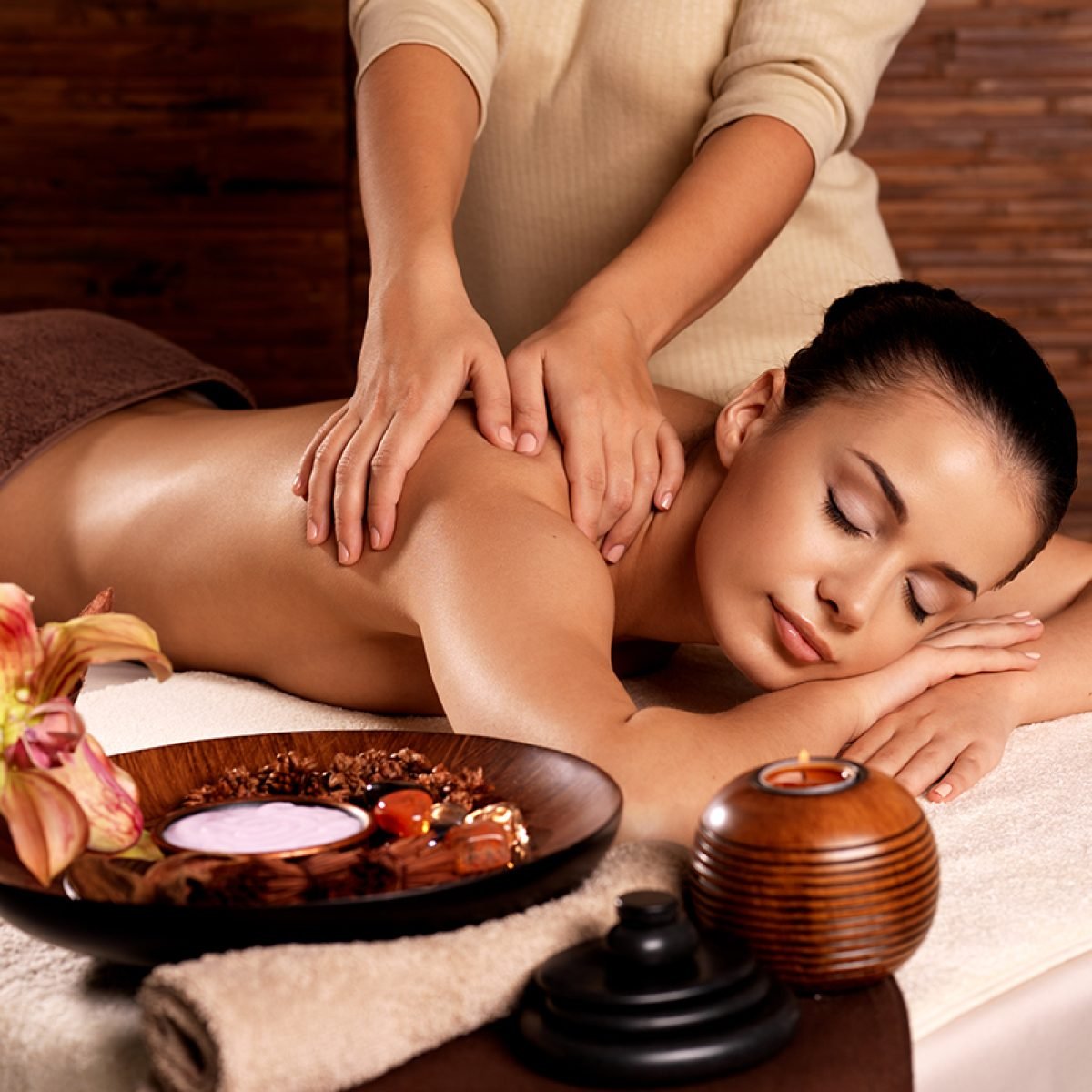 Masseur doing massage on woman body in the spa salon. Beauty treatment concept.